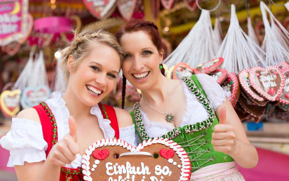 Zwei Frauen im traditionellen bayerischen Dirndl feiern das Oktoberfest mit den besten Oktoberfest-Slots.